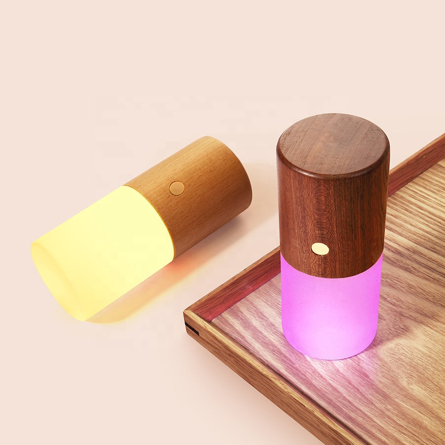 Two wooden lamps with colorful LED lights on a wooden surface.