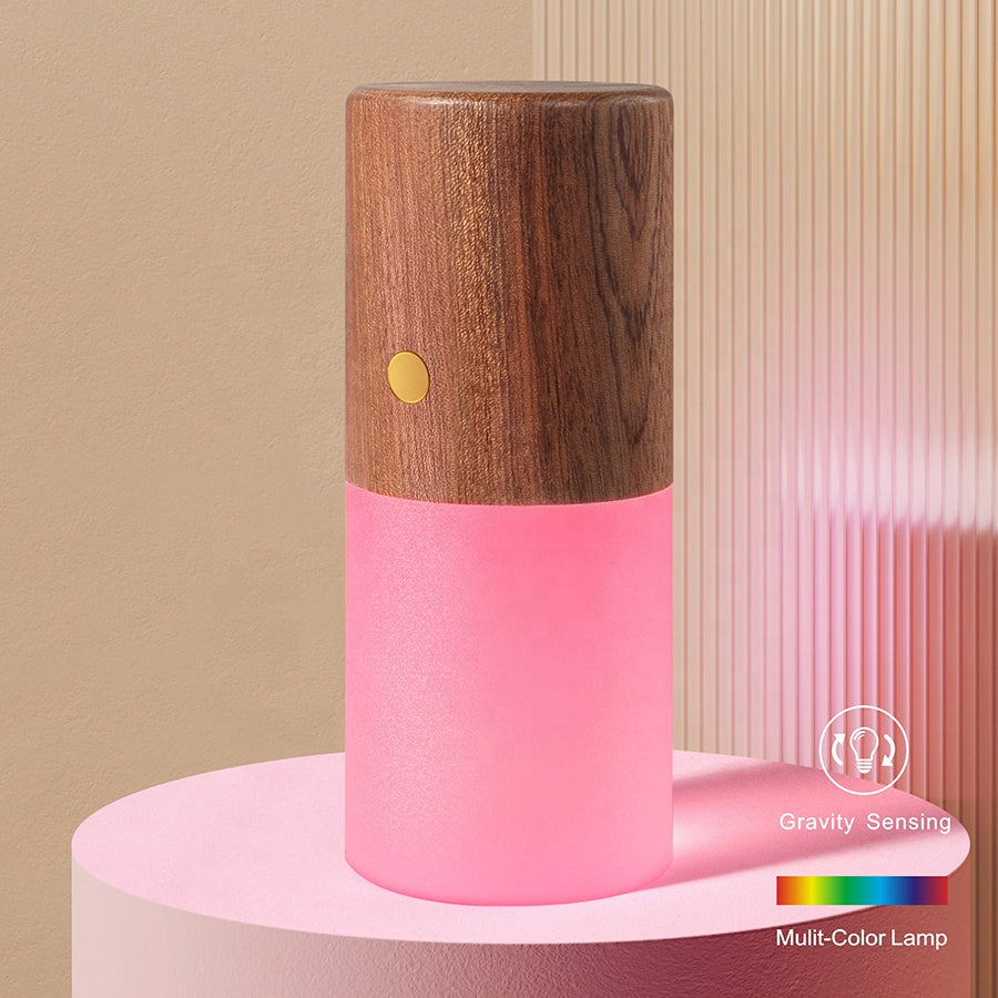 Pink multicolor lamp with wooden top on a beige background. rechargeable RGB wooden table lamp Pakistan, gravity flip night light USB‑C.