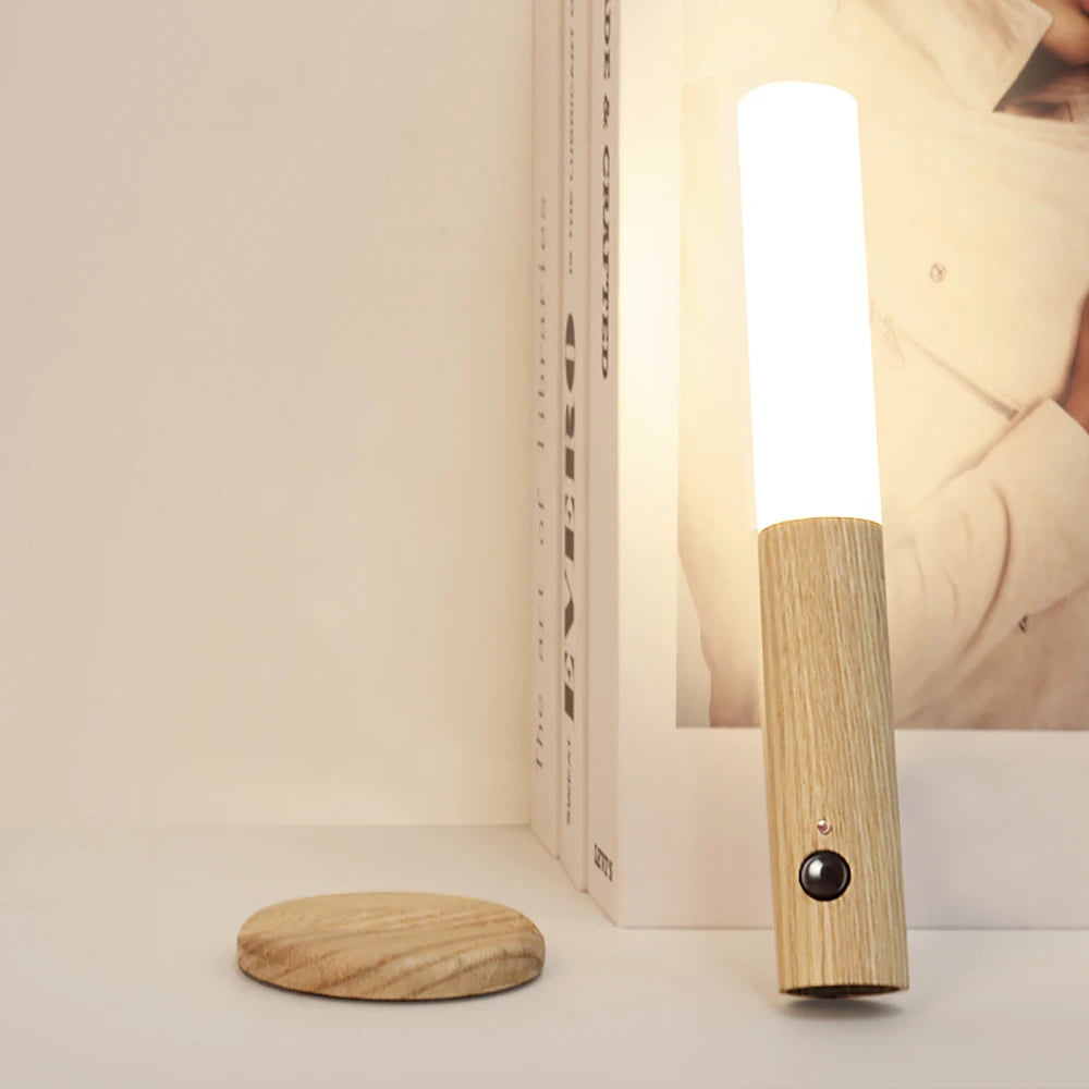 Wooden lamp with a light bulb on a white surface. magnetic motion sensor night light, wooden rechargeable night lamp.