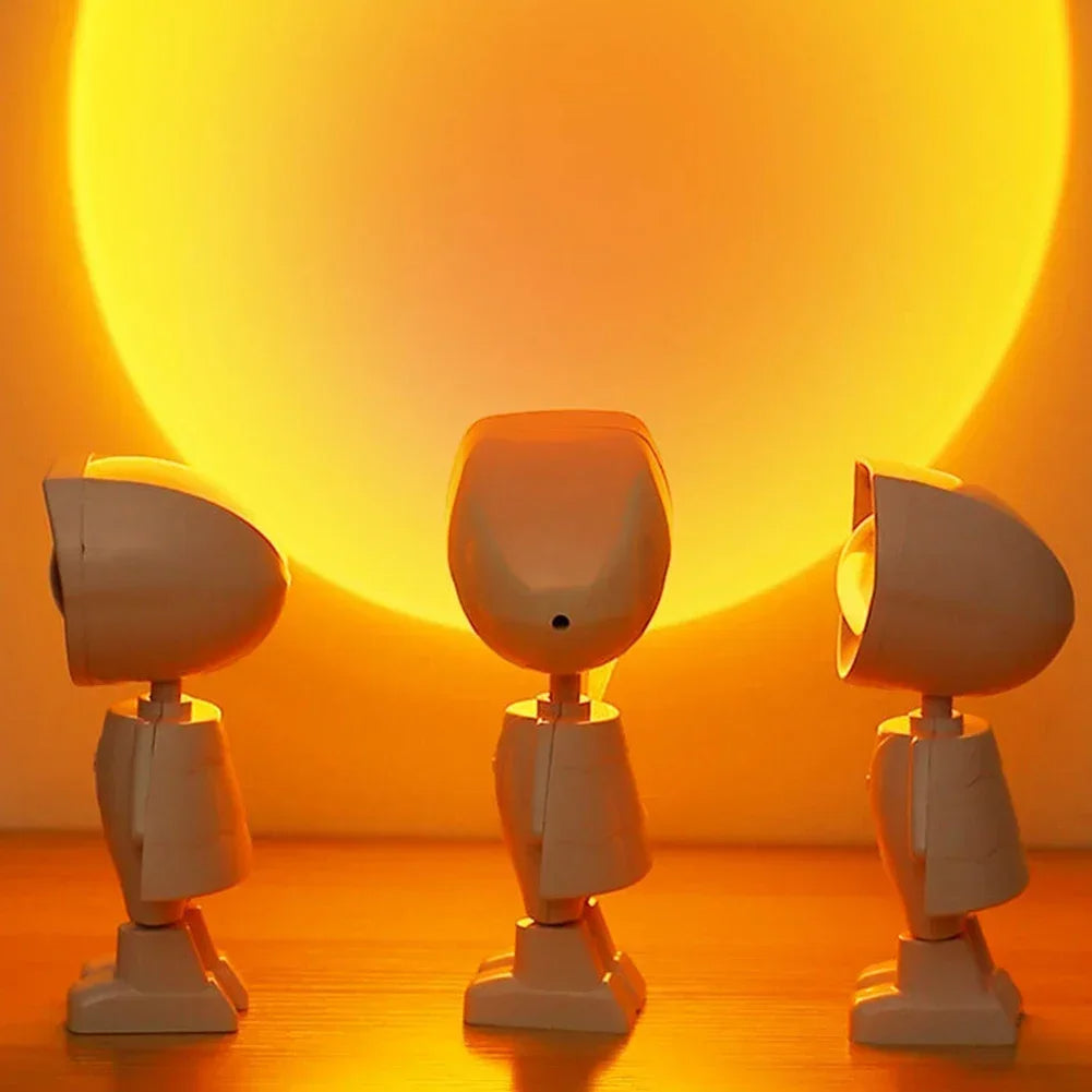 Three robot figures standing in front of a large yellow circle on a wooden. sunset lamp astronaut projector Pakistan, sunset projection lampurface.