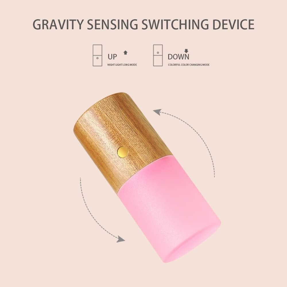 Gravity sensing switching device with wooden top and pink bottom on a beige background. rechargeable RGB wooden table lamp Pakistan, gravity flip night light USB‑C.